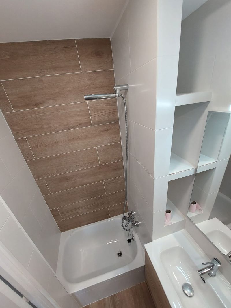 Reforma de baño con bañera y alicatado efecto madera en el Maresme
