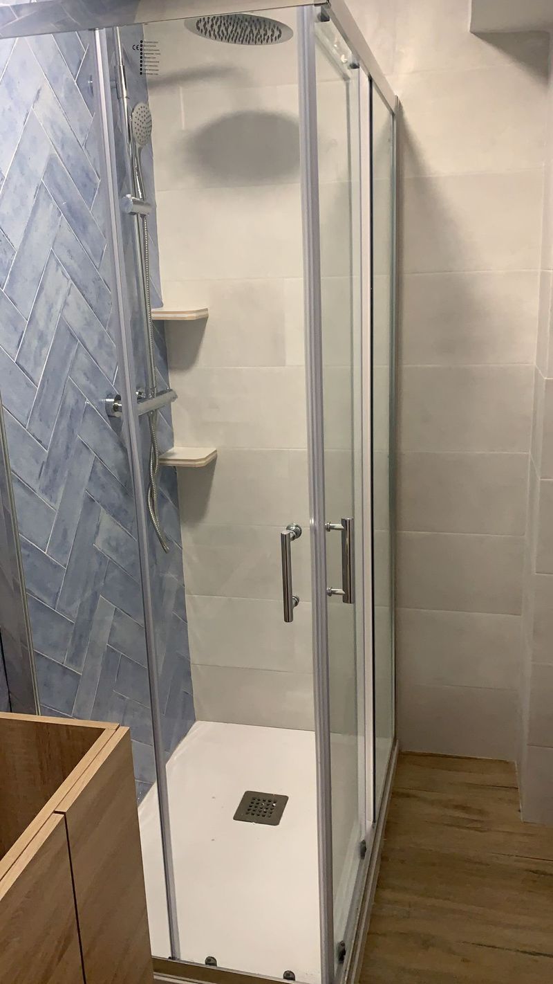 Reforma de baño con mampara de ducha y azulejo espiga en el Maresme
