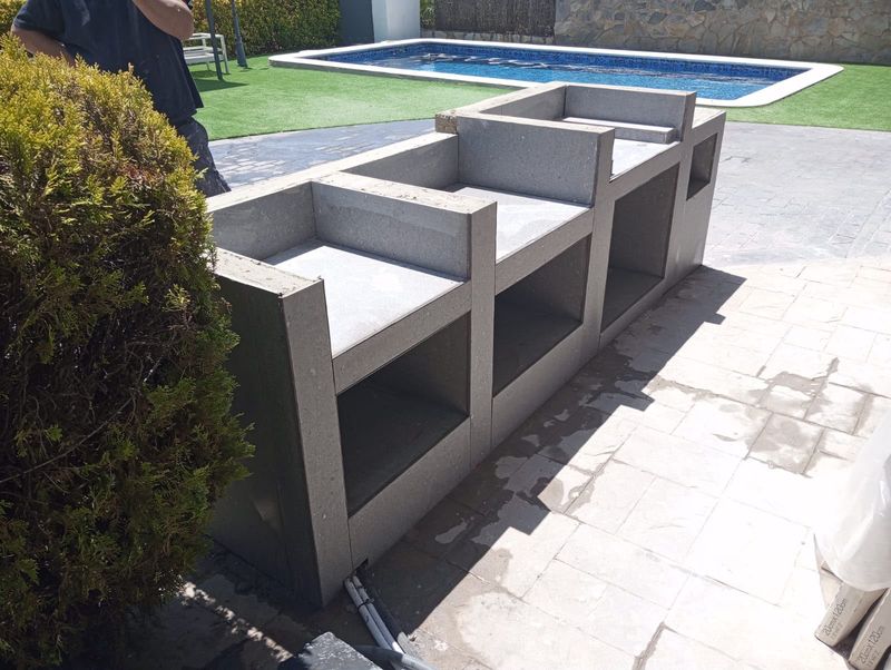Cocina exterior de obra junto a la piscina en el Maresme