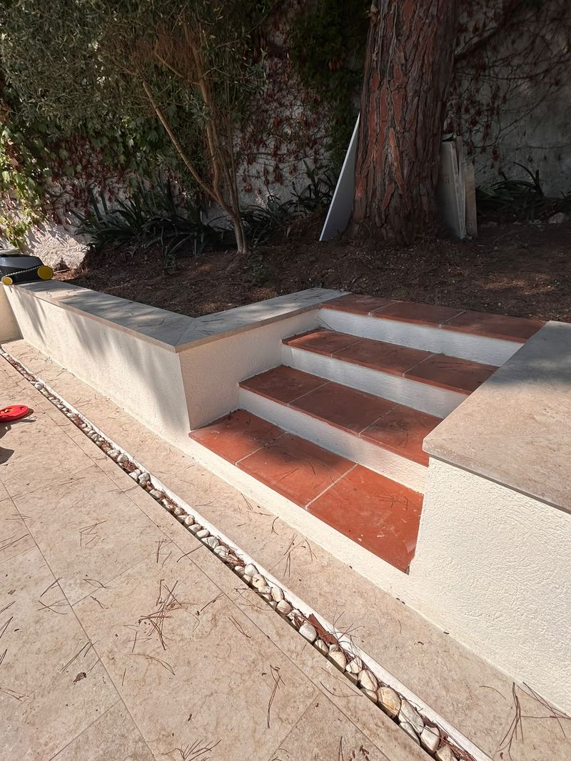 Escalera exterior y muro de obra reformados en Barcelona