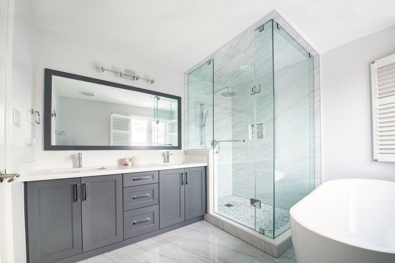 Reforma de baño moderno con ducha de obra y doble lavabo en Barcelona
